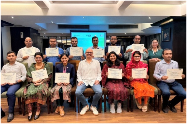 Participants holding up certificates and posing for a group photograph.