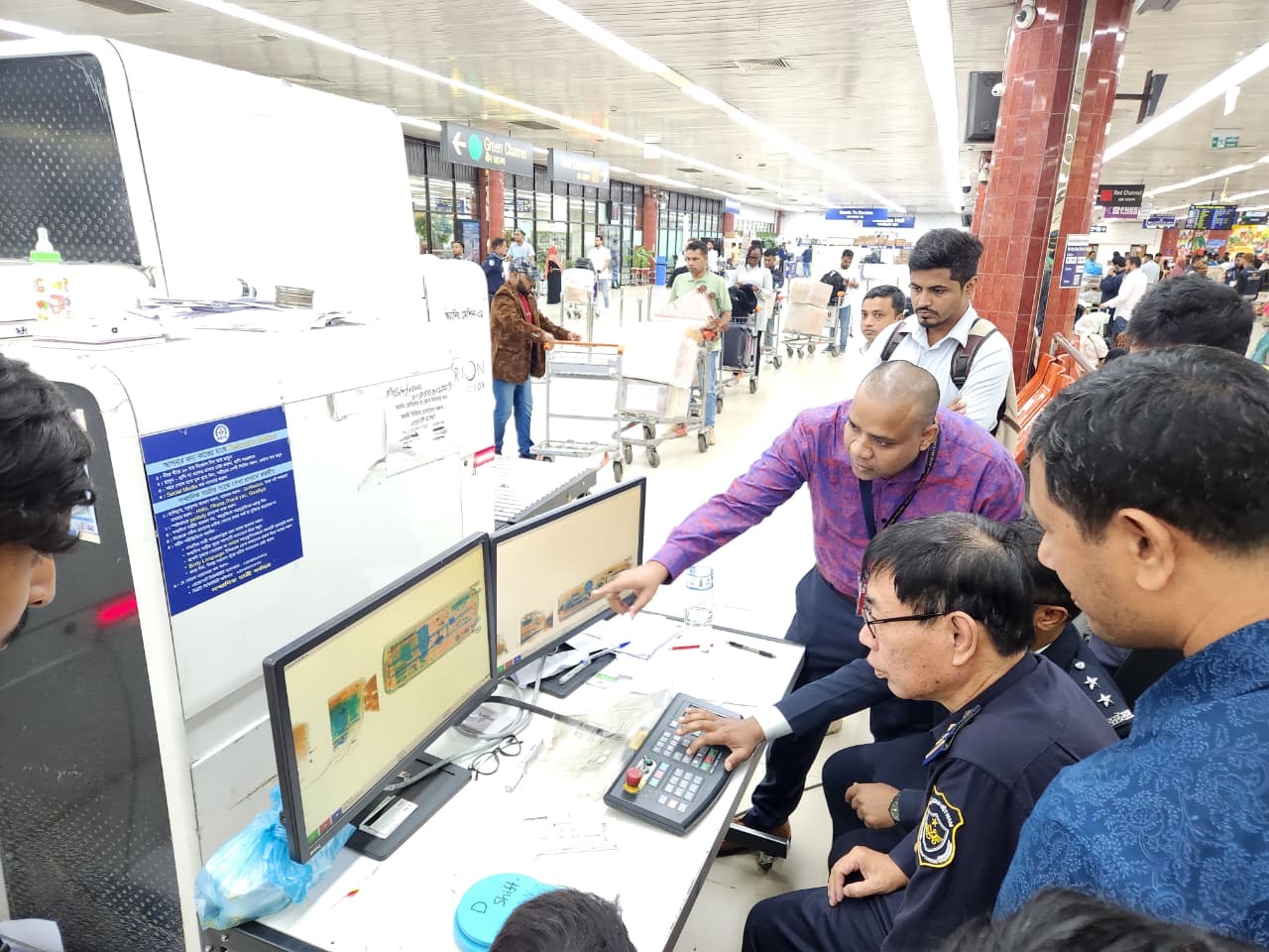 Participating officials around a X-ray machine during a demonstration