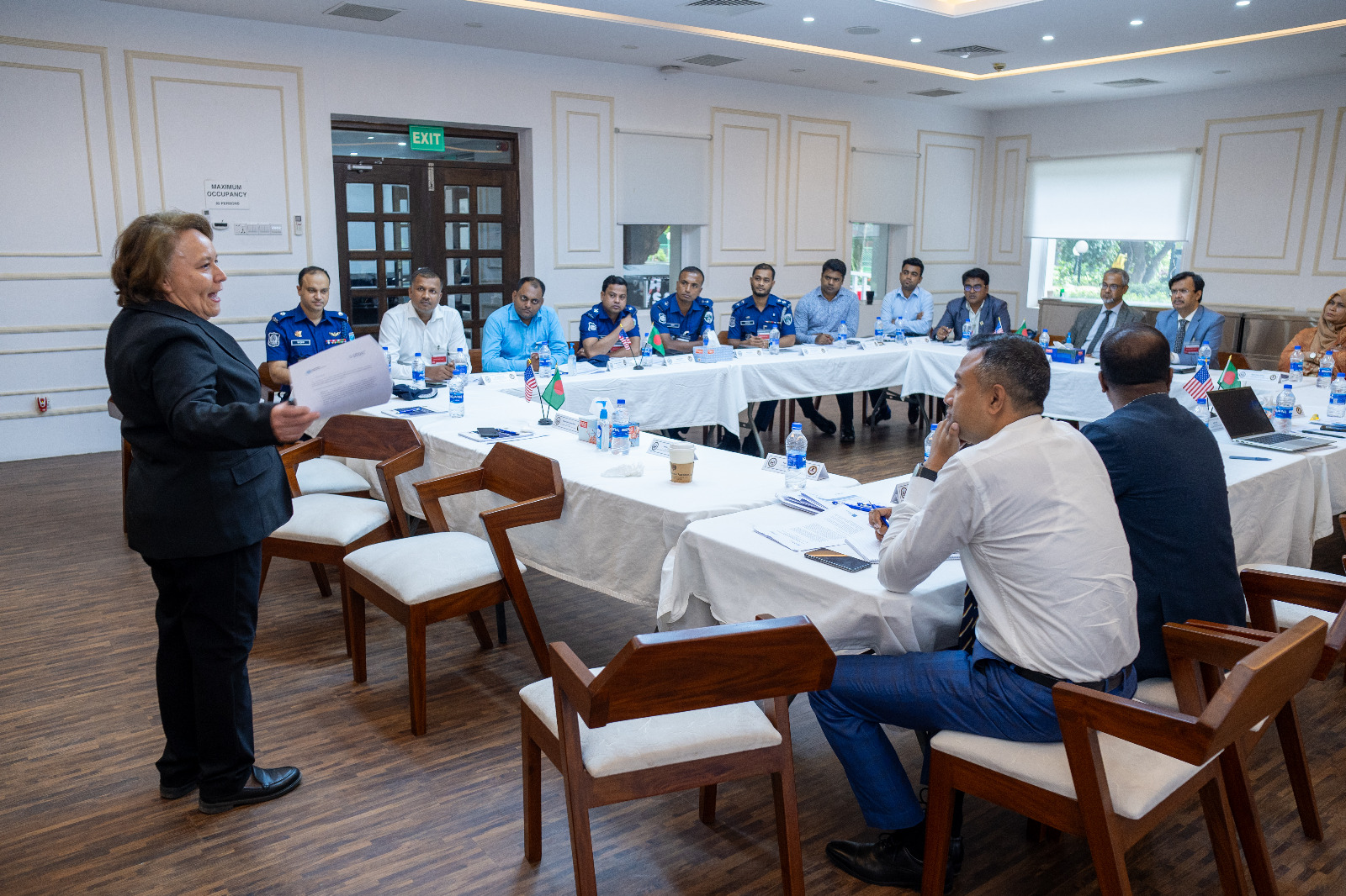 A female participant speaking at the Roundtable as other participant look on