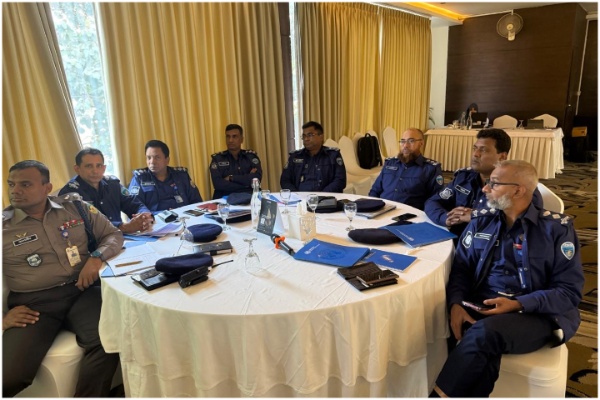 Participants seated around a table, listening to the discussions.