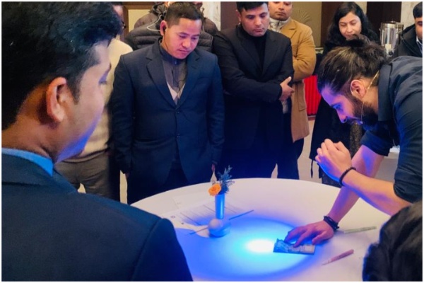 Participants standing around a table as a facilitator scans a document.