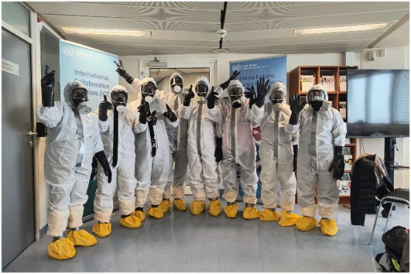 Participants wearing PPE kits and safety equipment, and posing for a group photograph.