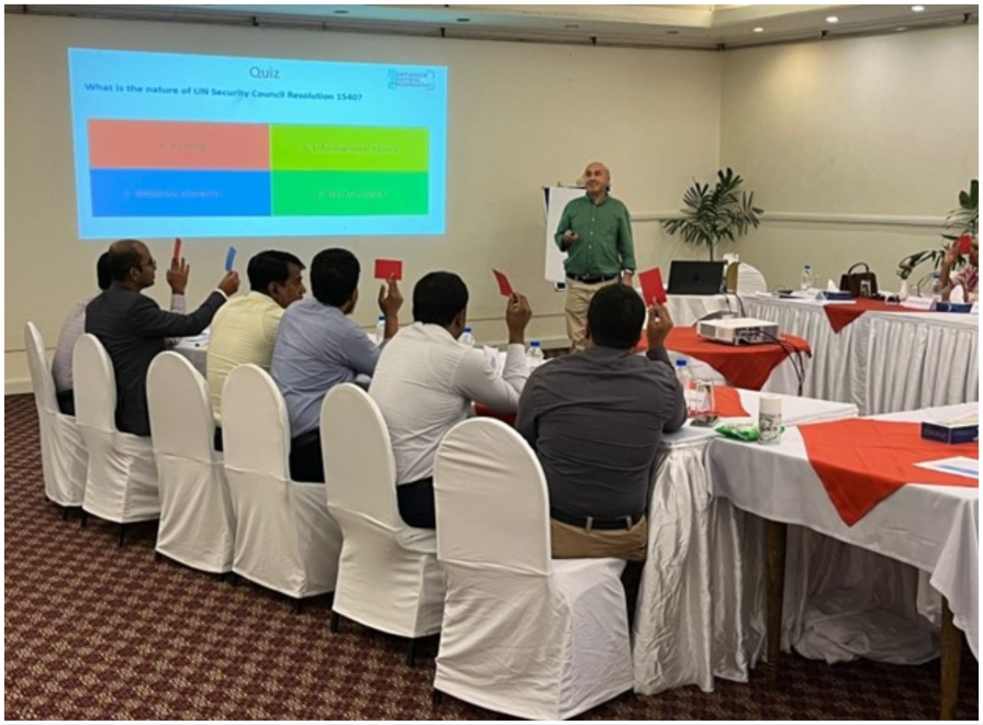 Participants looking towards the screen as the trainer looks on, during a group activity.